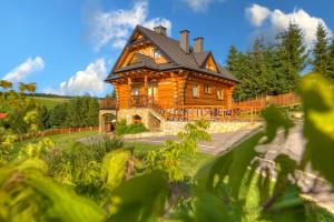 a large log cabin with a black roof at Dom z bala in Tylicz