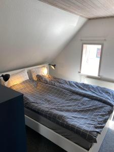 - un lit avec une couette bleue dans l'établissement byhus centralt i bogense, à Bogense