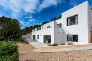 una casa blanca con muchas ventanas en Villa Sky Line, en Es Cubells