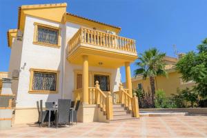 Una casa amarilla con balcón en la parte superior. en Villa Rose, en Orihuela