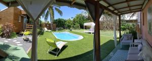 a backyard with a swimming pool and green grass at Villa Rosa Karibella in Saint-François
