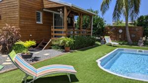 un cortile con piscina, sedie e una casa di Villa Rosa Karibella a Saint-François