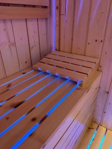 uma cama de madeira numa sauna com luzes azuis em Terrazza Aragon Room and SPA em Nápoles