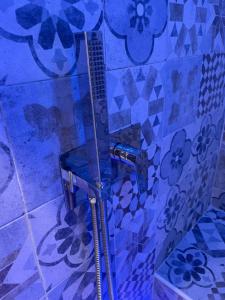 a shower in a bathroom with blue tiles at Terrazza Aragon Room and SPA in Naples