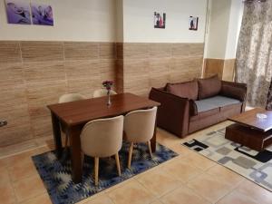 a living room with a table and a couch at Magic Studio Pool View, New Cairo in Cairo