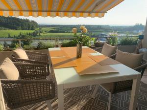 a table and chairs on a patio with a view at Hochwertige Sonneninsel mit Aussicht in Tettnang