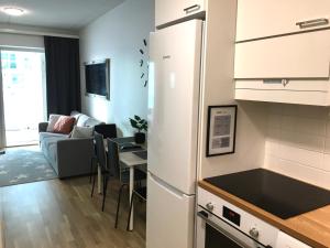 a kitchen and living room with a refrigerator and a table at StarHomes Double Lux 10 in Oulu