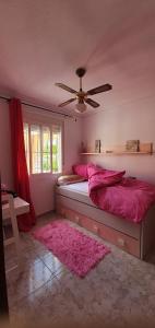 a bedroom with a pink bed and a ceiling fan at Villa pink Ambience in Mazarrón