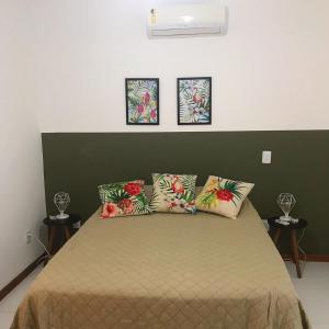 a bedroom with a bed with a green headboard at Pitaya Beach House - Charming Village By the Sea in Salvador