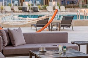 a couch sitting next to a pool with a hammock at Horizon Blu Boutique Hotel in Kalamata