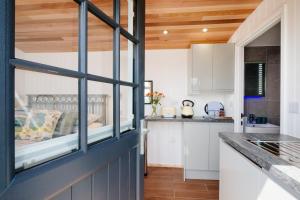 a kitchen with white cabinets and a window at Mount View Overnight Accommodation in Penzance