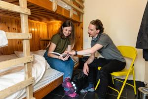 mężczyzna i kobieta siedzący na łóżku w obiekcie Highland Basecamp w mieście Lochaline