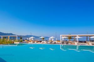 a large swimming pool with chairs and umbrellas at Horizon Blu Boutique Hotel in Kalamata