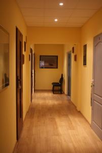 un couloir vide avec un banc dans une pièce aux murs jaunes dans l'établissement Hostel Zamość, à Zamość