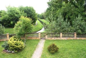 a fence with a path in a yard with a creek at Hostel Zamość - pokoje gościnne - bezpłatny parking in Zamość