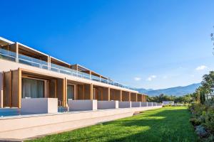 an exterior view of a building with a green lawn at Horizon Blu Boutique Hotel in Kalamata