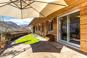 eine Terrasse mit einem Sonnenschirm auf einem Haus in der Unterkunft Trento View in Trient