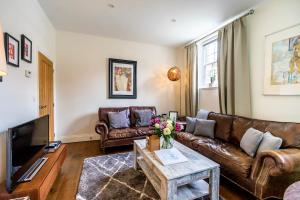 uma sala de estar com sofás de couro e uma televisão em Middlethorpe Manor - No 5 Lazy Days and Explore em York