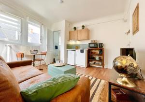 a living room with a couch and a table at Le Mans - Au Calme - Stationnement Facile - Proche Centre Ville et Gare in Le Mans