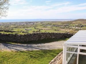 una vista da una casa con un muro di pietra di Fron Oleu a Caernarfon