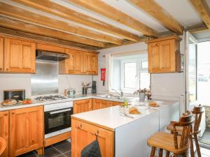 una cucina con armadi in legno e piano cottura. di Fron Oleu a Caernarfon