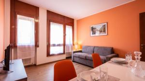 uma sala de estar com um sofá e uma mesa em Italianway - Aquileia 53 em Udine