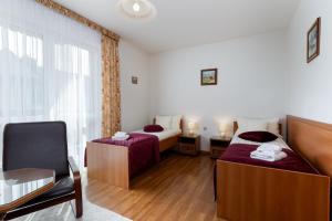 a hotel room with two beds and a chair at Willa Jerrego in Szczyrk