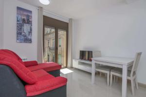 uma sala de estar com um sofá vermelho e uma mesa branca em Apartamento ideal en Manresa em Manresa