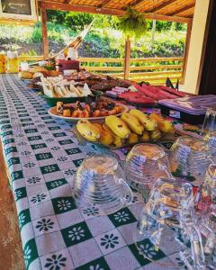 una mesa con plátanos y otros alimentos. en Pousada Canastra Mineira, en São Roque de Minas