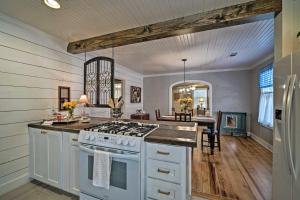a kitchen with a stove top oven in a room at Cozy Brenham Cottage with Private Patio and Yard! in Brenham
