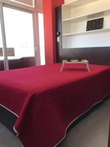 a red bed with a table on top of it at Viví Home in Mar del Plata