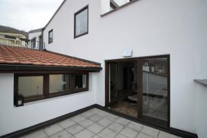 an external view of a white house with sliding glass doors at Blue apartment over Prizren roofs in Prizren