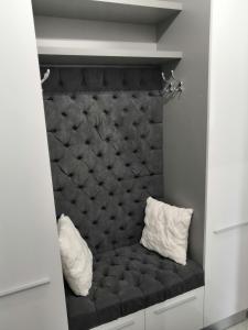 a black bed with two white pillows on it at ONYX - Utopia Aparthotel in Braşov