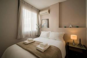 1 dormitorio con 1 cama blanca grande y toallas. en BHomy Paulista Confortável na Alameda Itu L114, en São Paulo