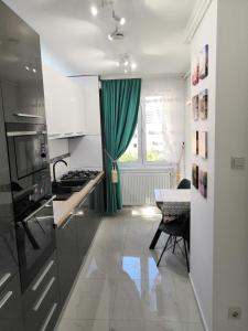a kitchen with a green curtain and a table at ONYX - Utopia Aparthotel in Braşov