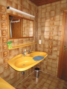 a bathroom with a yellow sink and a mirror at Ferienwohnung Panorama in Wertheim +10 photos