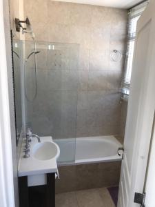 a bathroom with a tub and a sink and a shower at Viví Home in Mar del Plata