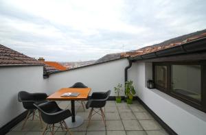 a balcony with a table and chairs on a building at Blue apartment over Prizren roofs in Prizren