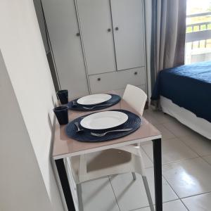 a table with two plates on it in a bedroom at Flat 308 in Teresina