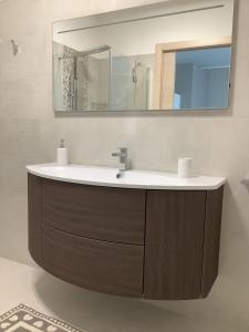 La salle de bains est pourvue d'un lavabo et d'un miroir. dans l'établissement VILLAFIORE, à Azzano San Paolo