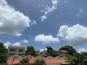 a building with a blue sky and clouds at Villas Bakalar in Bacalar