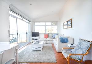 a living room with a couch and a table at Oceanfront Penthouse in Muizenberg