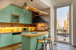 una cucina con armadi verdi e 2 sgabelli da bar di Riviera House Apartment Sea View group and family By HouseinNaples a Napoli