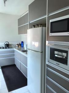 a kitchen with a white refrigerator and a microwave at Apartamento Marquinho in Urubici