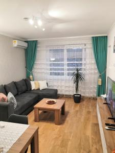 a living room with a couch and a table at ONYX - Utopia Aparthotel in Braşov