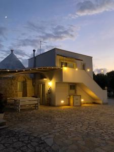 a house with a mountain in the background at Il Trullo Bianco in Selva di Fasano
