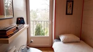 um quarto com uma janela e uma cama em frente a uma porta em L'Atelier du Peintre em Clairvaux-les-Lacs