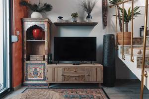 a television on a wooden stand in a living room at Studio Apartman Bohem in Zagreb