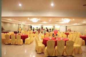 un salón de banquetes con mesas y sillas rojas y amarillas en De Luxe Hotel, en Cagayan de Oro