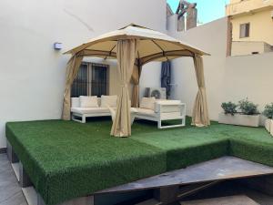 a gazebo with two couches and a green lawn at Neko Boutique Hotel in Cagliari